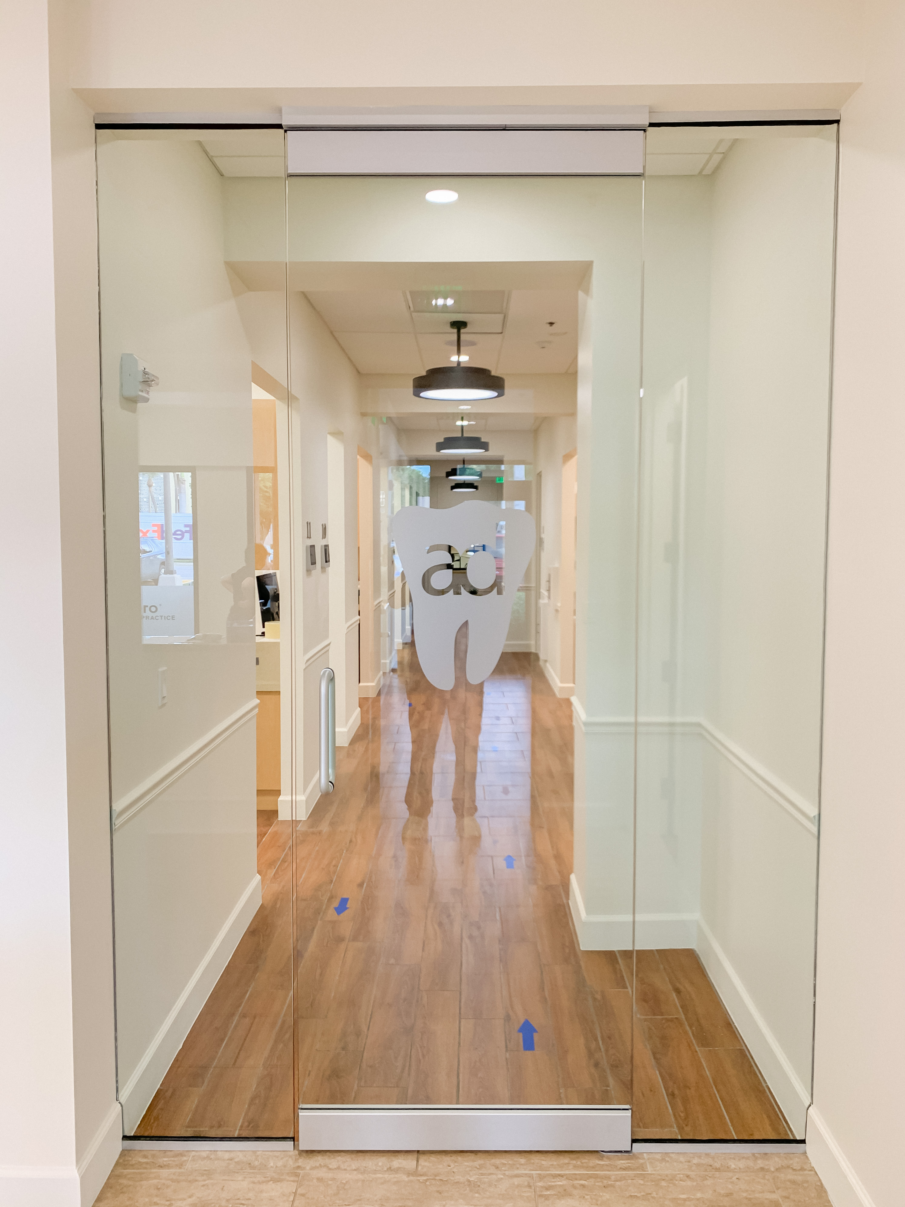 Glass entrance wall with the Amores Dental logo